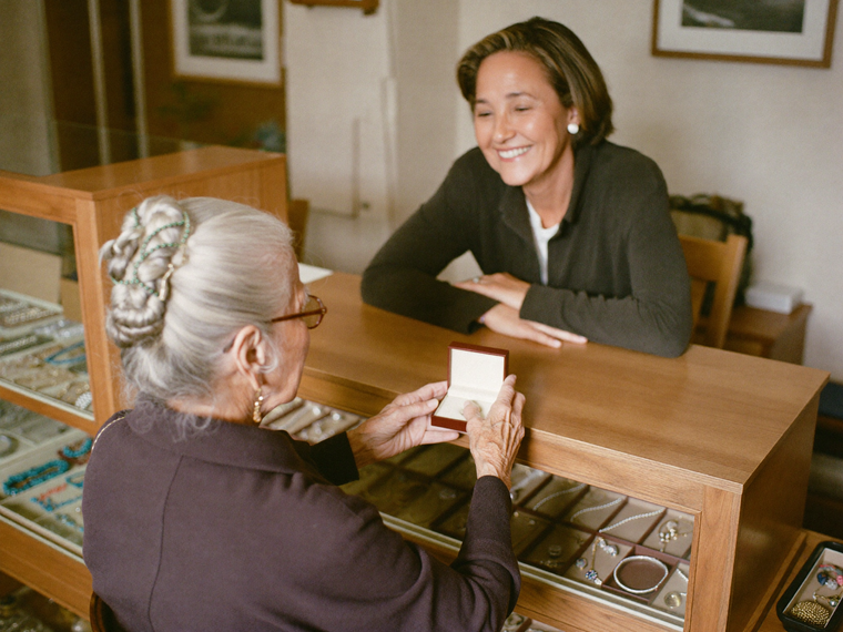 Margaret Prescott handing a wrapped piece across the counter